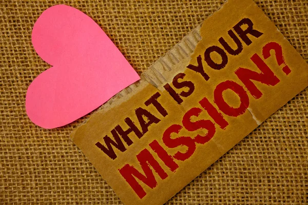 Word writing text What Is You Mission Question. Business concept for asking someone about his plans and to-do list Torn thick paper blood and pigment red texts jute sack pink paper heart.