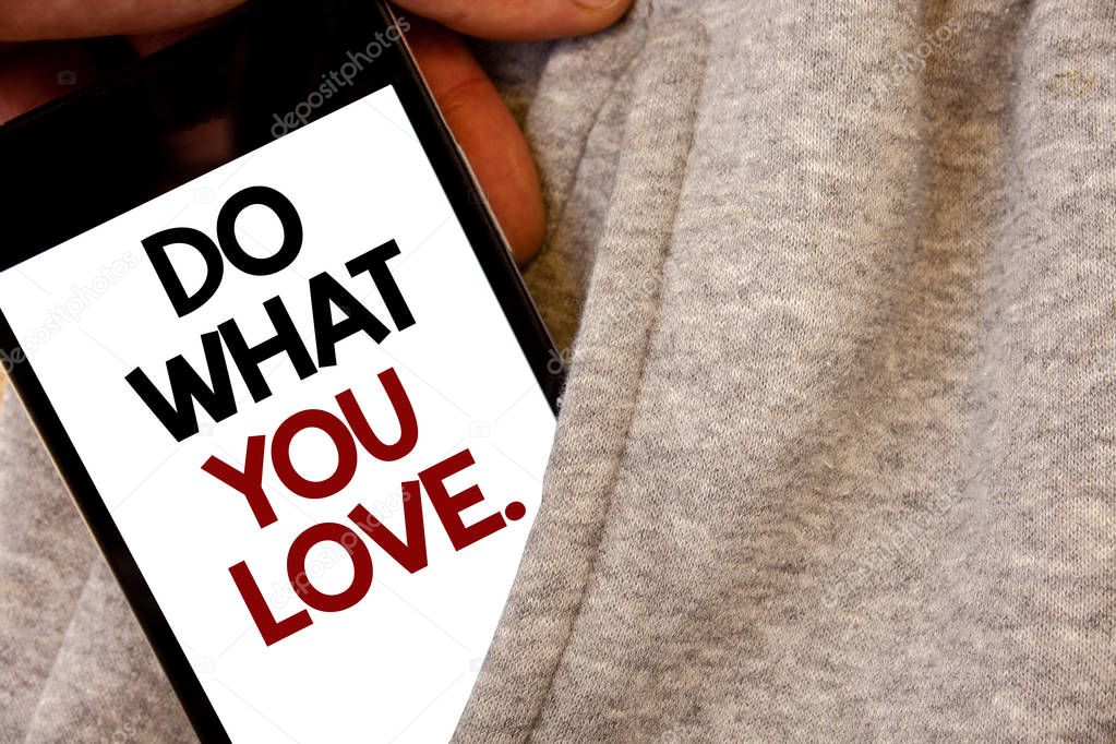 Text sign showing Do What You Love.. Conceptual photo Positive Desire Happiness Interest Pleasure Happy Choice Words written black Phone white Screen Hand holding pocket white tracksuit.