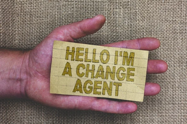 Conceptual hand writing showing Hello I am A Change Agent. Business photo showcasing Promoting and enabling difference evolution new Thick gray paper with words human hands jute sack background.