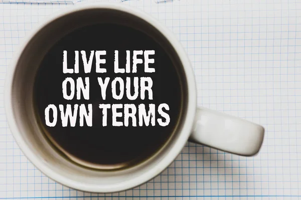 Writing note showing Live Life On Your Own Terms. Business photo showcasing Give yourself guidelines for a good living Coffee mug with black coffee floating some white texts on white paper.