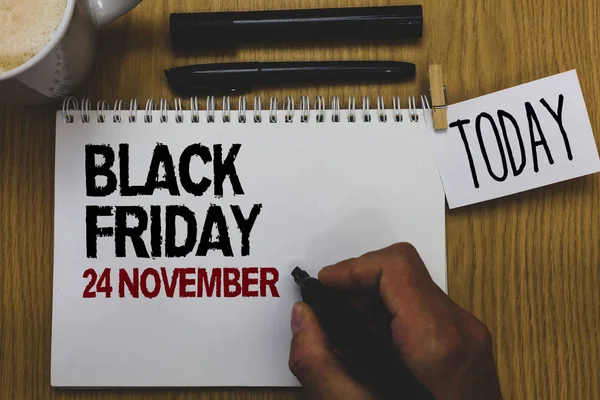 Conceptual hand writing showing Black Friday 24 November. Business photo text Special sales Thanksgiving discounts Clearance Written on paper hand hold pen clipper grip sticky note black pen.