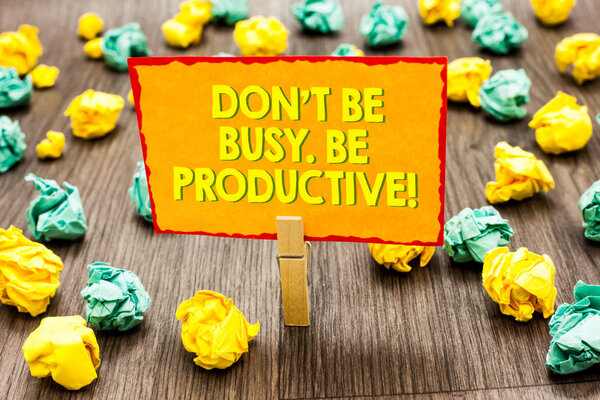 Handwriting text Don t not Be Busy. Be Productive. Concept meaning Work efficiently Organize your schedule time Paperclip hold written yellow page colorful paper lobs laid on wooden floor.