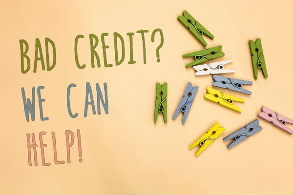 Text sign showing Bad Credit question We Can Help. Conceptual photo Borrower with high risk Debts Financial Yellow base with painted texts colorful paper clips laid randomly on ground. — Stock Photo, Image