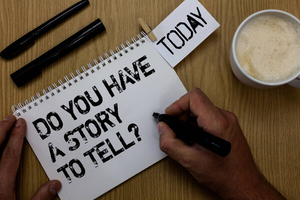 Text sign showing Do You Have A Story To Tell question. Conceptual photo Storytelling Memories Tales Experiences Paperclip retain written notepad hand hold marker coffee black pen on woody desk.