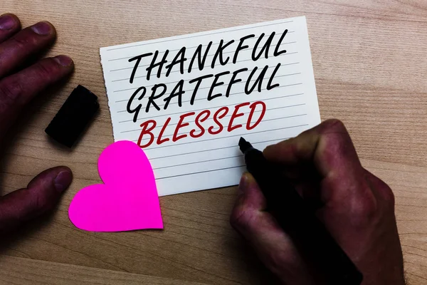 Text rukopisu psaní vděčný vděčný požehnaný. Pojetí znamená zhodnocení vděčnost dobrou náladu postoj zapsaných na Poznámkový blok ruka drží značka s láskou srdce dřevěné pozadí. — Stock fotografie