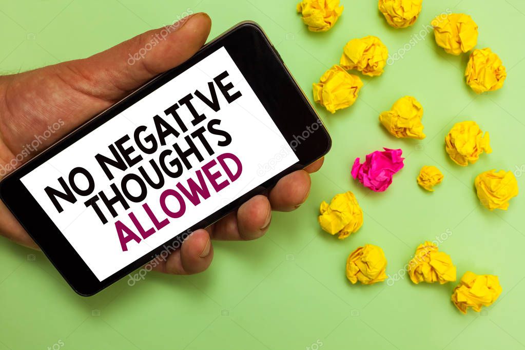 Word writing text No Negative Thoughts Allowed. Business concept for Always positive motivated inspired good vibes Man holding cell phone white screen looking messages crumpled papers.