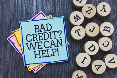 Handwriting text Bad Credit question We Can Help. Concept meaning Borrower with high risk Debts Financial Black wooden deck written sticky note beside some round woody alphabets. clipart