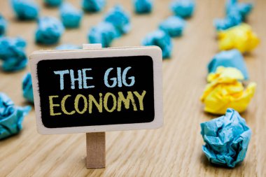 Conceptual hand writing showing The Gig Economy. Business photo text Market of Short-term contracts freelance work temporary poster board with blurry paper lobs laid serially mid yellow lob. clipart