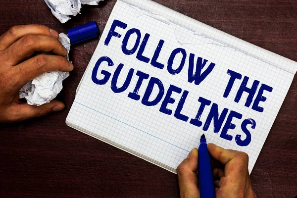 Writing note showing Follow The Guidelines. Business photo showcasing Manual of Style Follow a Specified Rule Accordingly Man holding marker notebook page crumpled paper several tries mistakes. — Stock Photo, Image