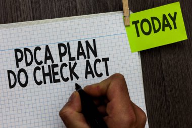 Word metin Pdca Plan yapmak kontrol Yasası yazma. Çözme sorunlar marker defter clothespin tutun hatırlatma ahşap arka plan tutan adam sürecinde iş kavramı Deming tekerlek için geliştirilmiş.