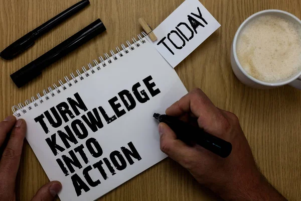 Text sign showing Turn Knowledge Into Action. Conceptual photo Apply what you have learned Leadership strategies Paperclip retain written notepad hand hold marker coffee black pen on woody desk. — Stock Photo, Image