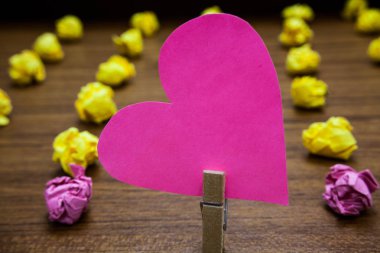 Tasarım iş kavramı boş şablon kopya alanı metin reklam Web sitesi için ahşap zemin üzerinde metin bulanık kağıt ile pembe kalp lobs ataç tutun izole