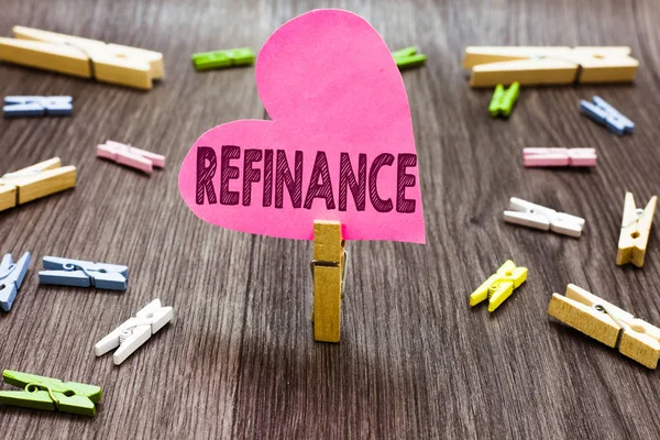 Writing note showing Refinance. Business photo showcasing Finance again Replacement of existing debt with another one Clothespin holding pink paper heart several clothespins wooden floor. — Stock Photo, Image