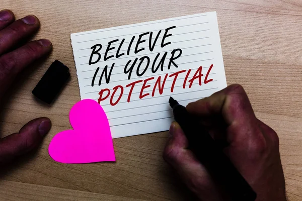 Handwriting text writing Believe In Your Potential. Concept meaning Have self-confidence motiavate inspire yourself Written on notepad hand hold marker with love heart wooden background.