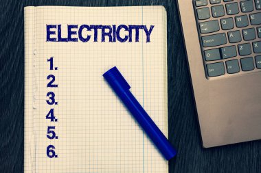 Elektrik gösterilen metin işareti. Kavramsal fotoğraf enerji yüklü parçacıklar açık defter varlığını ortaya çıkan formu sayfa siyah kalemi bilgisayar klavye ahşap arka plan murabba.