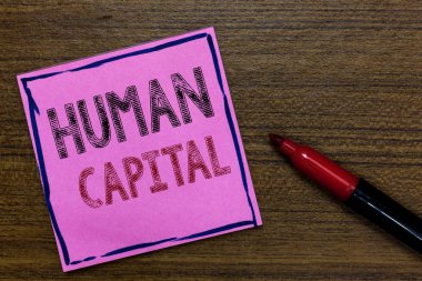 Text sign showing Human Capital. Conceptual photo Intangible Collective Resources Competence Capital Education Purple Paper Important reminder Communicate ideas Marker Wooden background. clipart