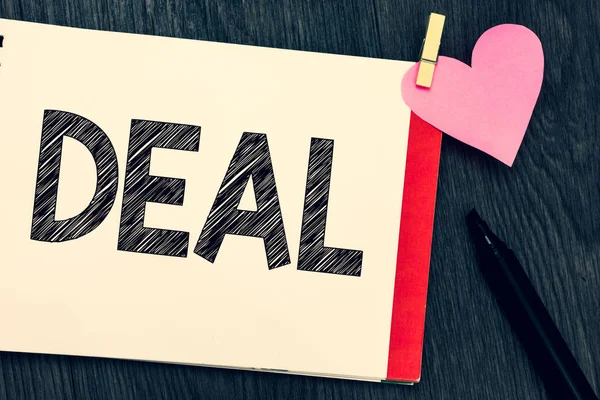 Writing note showing Deal. Business photo showcasing Agreement entered into by two or more parties for their mutual benefit Notebook page marker clothespin holding paper heart wooden background. — Stock Photo, Image