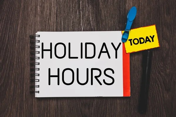 Writing note showing Holiday Hours. Business photo showcasing Schedule 24 or 7 Half Day Today Last Minute Late Closing Open notebook white page clothespin holding reminder wooden background.