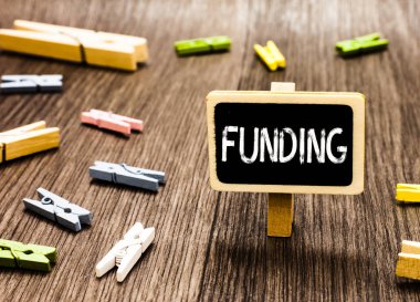 Finansman yazma el yazısı metin. Organizasyon hükümeti tarafından sağlanan birkaç clothespins ayakta Blackboard amaç için para anlam kavramı dağınık dağınık ahşap zemin.