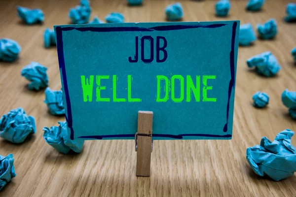 Handwriting text writing Job Well Done. Concept meaning Well Performed You did it Cheers Approval Par Accomplished Clothespin holding blue paper note crumpled papers several tries mistakes. — Stock Photo, Image