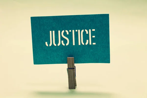 手写文本正义。概念意义公正公正或公平的法律管理的质量规则衣夹持有绿松石纸重要的沟通信息的思想. — 图库照片