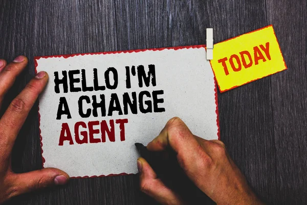 Handwriting text writing Hello I am A Change Agent. Concept meaning Promoting and enabling difference evolution new Hand grip black marker writing text paperclip stick written page woody deck.