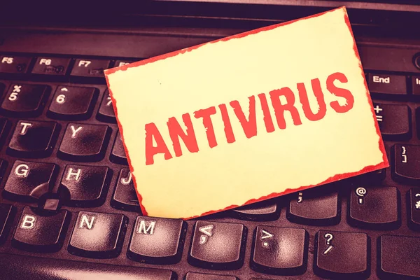 Escribiendo nota mostrando Antivirus. Software de presentación de fotos de negocios diseñado para detectar y destruir virus informáticos Bloc de notas bordeado en blanco que recuerda insertado entre las teclas de la computadora portátil . — Foto de Stock