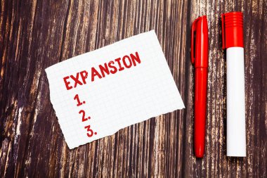 El yazısı metin genişleme. Kavramı anlam eylem daha büyük olmasını ya da bir şey boş parçalanmış dizin daha geniş genişleme ahşap yüzey üzerinde yazmak için grafik kağıdı iki kalem büyüklüğünde.