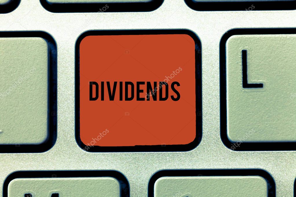 Word writing text Dividends. Business concept for sum of money paid regularly by company to shareholders out profits Keyboard key Intention to create computer message, pressing keypad idea.