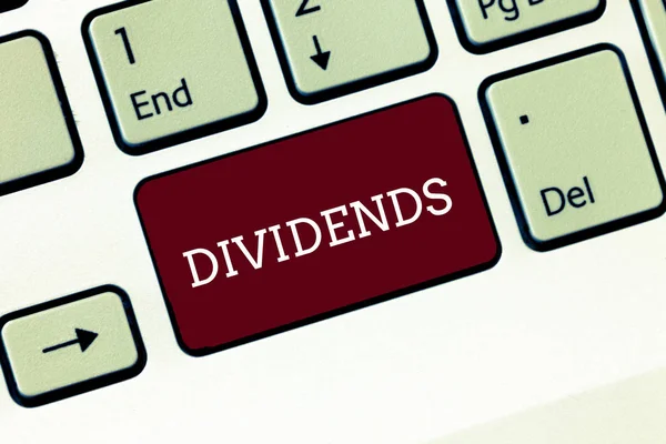Handwriting text Dividends. Concept meaning sum of money paid regularly by company to shareholders out profits Keyboard key Intention to create computer message, pressing keypad idea. — Stock Photo, Image