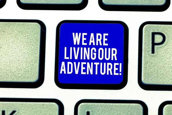 Handwriting text We Are Living Our Adventure. Concept meaning Exploring the world traveling life experience Keyboard key Intention to create computer message pressing keypad idea.