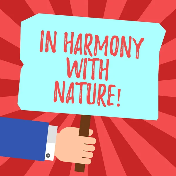 Handwriting text In Harmony With Nature. Concept meaning Meditation zen peaceful attitude spirituality Hu analysis Hand Holding Blank Colored Placard with Stick photo Text Space.