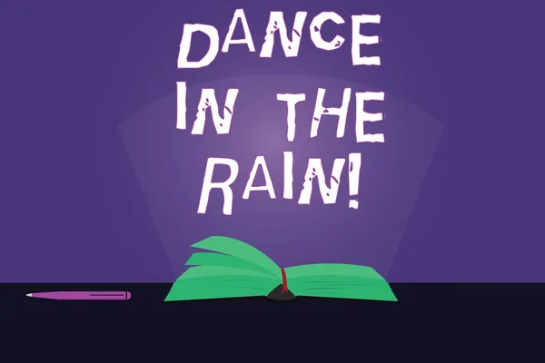 Writing note showing Dance In The Rain. Business photo showcasing Enjoy the rainy day childish activities happy dancing Color Pages of Book on Table with Pen and Light Beam Glaring.