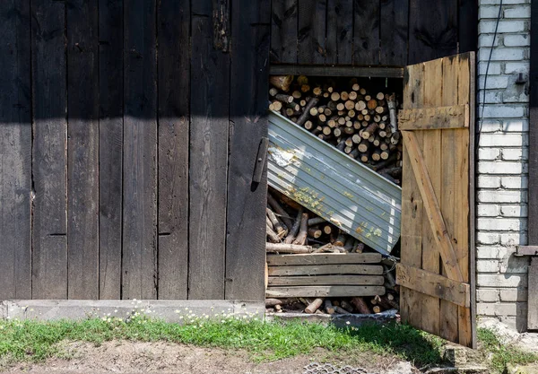 Gammal trä lada full med eld trä redo för vintern. Öppnade dörrar på byn ladan. — Stockfoto