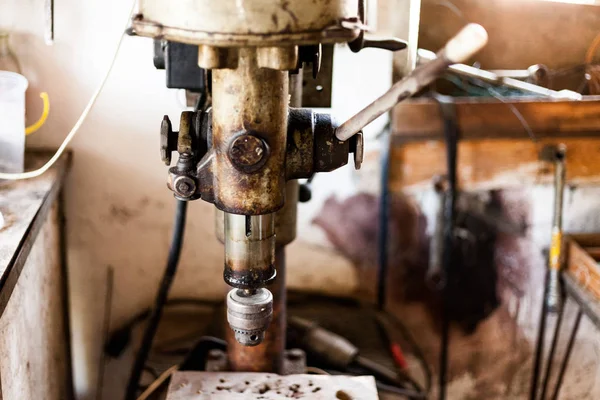 Μεταλλοβιομηχανία stand με μηχανή τρυπανιών. Αρχική workshop με σκληρά εργαλεία σχετικά με τη στάση μετάλλων. Παλιό σκουριασμένο χέρι εργαλείο τρυπάνι μηχανή στη μεταλλική βάση. — Φωτογραφία Αρχείου