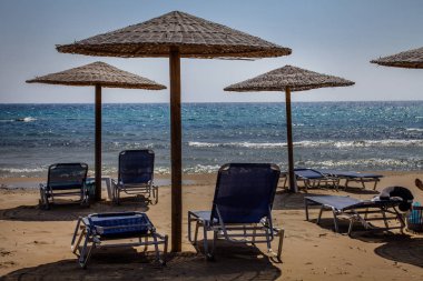 Okyanusa bakan Beach ayarlanabilir Lounge sandalye yatak. Ahşap şemsiye güneş ışığı ve ısı kapsayan. Seyahat hedef fikirler. Dalgalı mavi su ve ince kum.