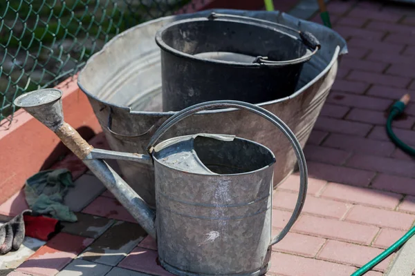 Watering buckets in the garden. Gardening concept image with metal bucket for water.