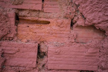 Kırmızı tuğla sert duvar. Düzgün bir şekilde düzensiz boşluklar arasında oluşturma harç ile mühürlenmiş. Dağınık Adobe yükleme. Kirli duvar örmek çalışmalarını.