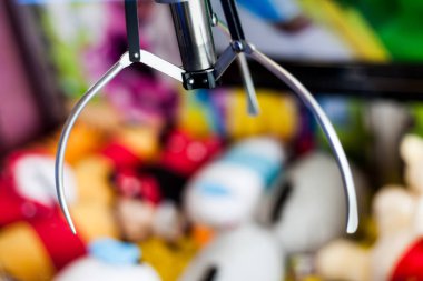 Slot makinesidir oyuncak vinç eğlence parkı içinde closeup çekim. Elektronik Arcade pençe tutma oyunu kapma için bir ödül olarak doldurulmuş. Bokeh etkisi fikirler fotoğraf.