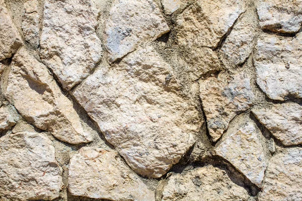 White Stoned Wall in Uneven Cut for Background. Closeup View of Chalky Dry Rock Formation in Abstract. Crazy Pattern of Rock Paved Structure Art of Masonry.