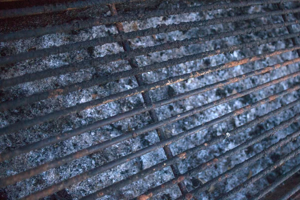 Nahaufnahme von Grillzubehör. Verbrennungen und Rost kleben am Stahlgitter. Holzkohle und Aschenreste in Grubenblech. Kochen im Freien durch Grillen. — Stockfoto