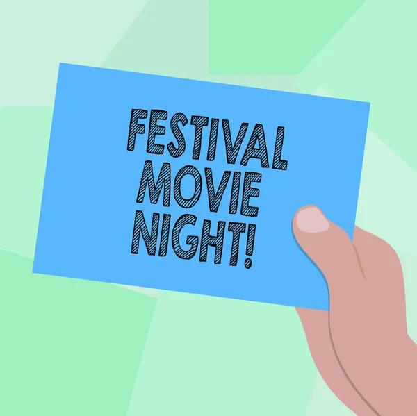 Conceptual hand writing showing Festival Movie Night. Business photo showcasing analysisy friends get together to watch movies together Drawn Hu analysis Hand Holding Blank Color Paper Cardboard.