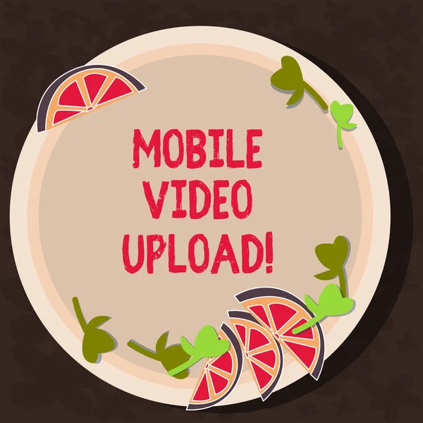 Text sign showing Mobile Video Upload. Conceptual photo add videos on website or blog using cell phone Cutouts of Sliced Lime Wedge and Herb Leaves on Blank Round Color Plate