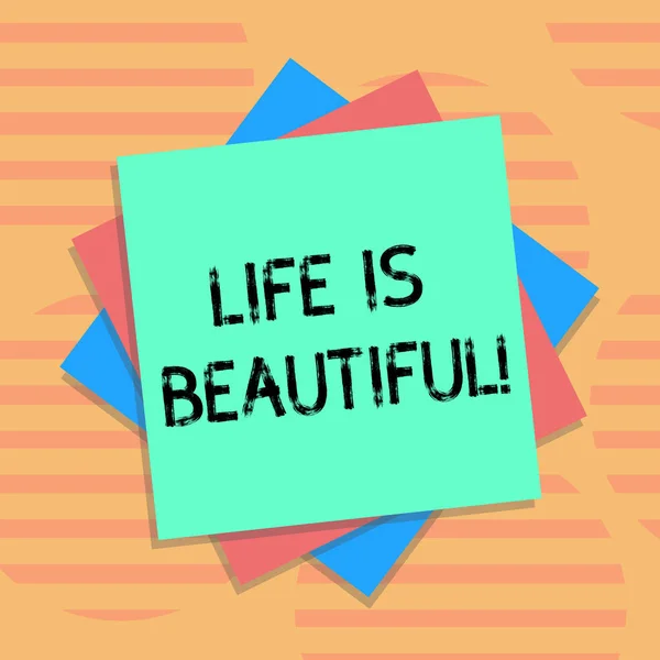 Текст слова Life Is Beautiful. Бизнес-концепция для наслаждения каждым моментом включает в себя семью или друзей природы, а также цветные листы бумаги и картонную фотографию с тенью. . — стоковое фото