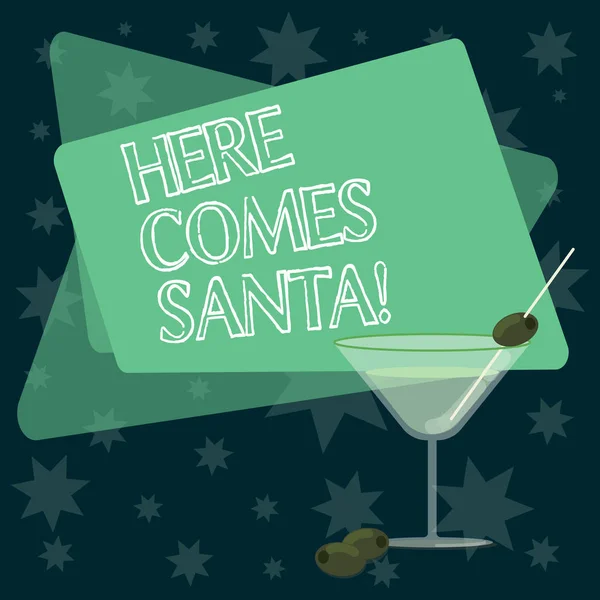 Escribiendo nota que muestra Here Comes Santa. Foto de negocios que muestra la canción de Navidad escrita e interpretada por Gene Autry Copa de vino de cóctel llena con aceituna en el borde Texto del espacio . —  Fotos de Stock