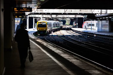 Birmingham, İngiltere - iki tren bir Mart 2018 diğer gelen veya Türkiye Park. Platform üzerinde yürüyen insan silüeti. Office yolun karşı tarafta biletleme.