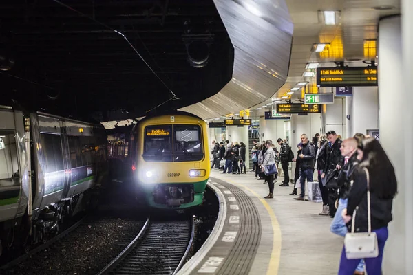 Birmingham, uk - März 2018 Pendler warten am Bahnhof auf die Ankunft des Zuges. zwei Reisebusse auf dem Bahngleis. Menschen in Jacken stehen am U-Bahn-Bahnsteig Schlange. — Stockfoto