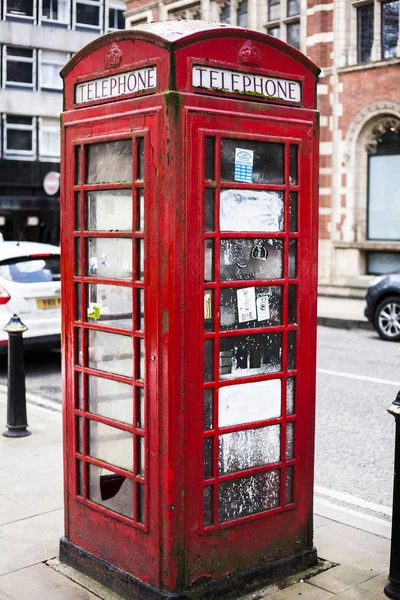 BIRMINGHAM, Reino Unido - Marzo de 2018 Cabina telefónica Rusty and Weathered Red Vintage de pie en la calle City. Fijación común del icono del teléfono público de Londres en la acera de las áreas urbanas del Reino Unido . — Foto de Stock