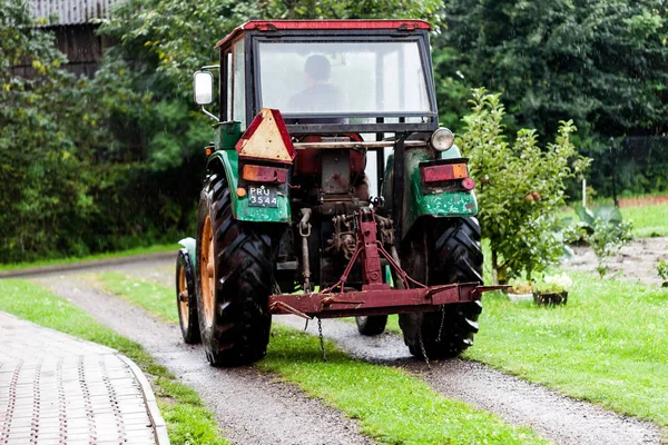 BIRMINGHAM, Royaume-Uni - Mars 2018 Mini faucheuse de foin de camion à quatre roues motrices dans la ferme avec chauffeur. Arbres et plantes fruitières dans la région. Bruine rend l'herbe plus fraîche et verte . — Photo