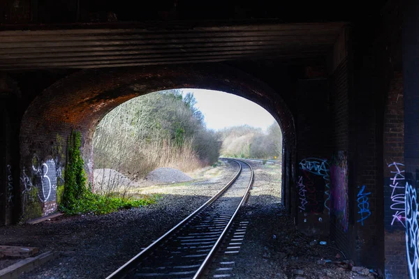 BIRMINGHAM, UK - March 2018 Underground. Gravel and Dry Twigs Around the Area. Vandalism on the Dirty Bricked Wall. Fresh Leaves Crawl up the Wall. — Stock Photo, Image